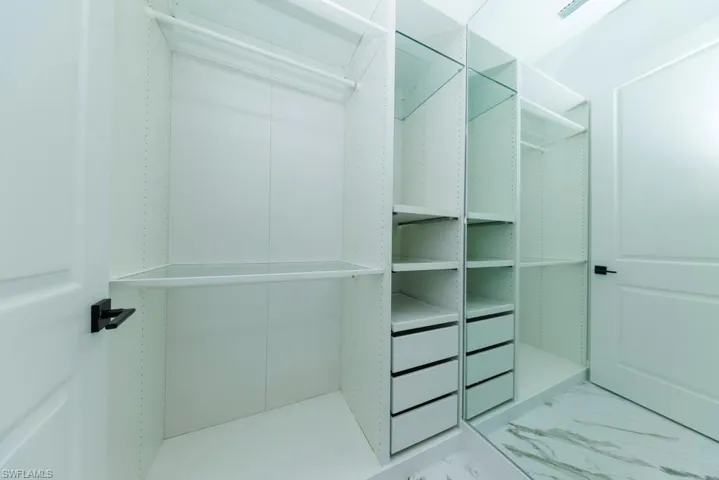 Spacious closet featuring marble look tiles
