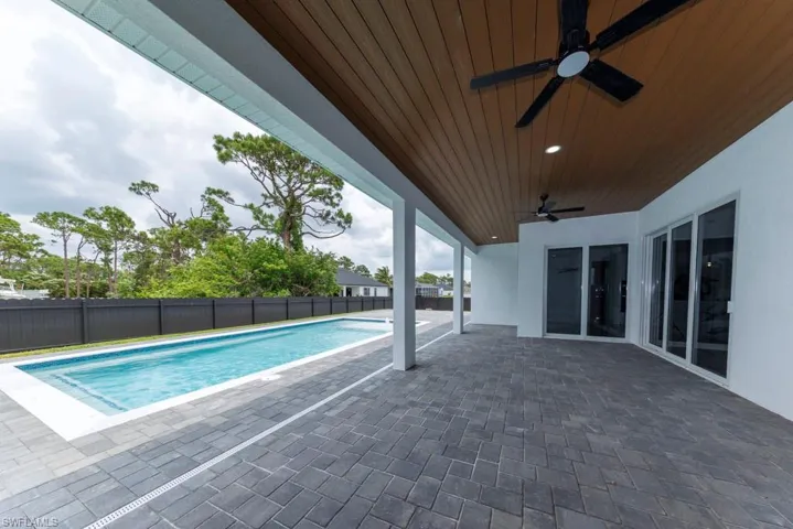 View of pool with ceiling fan, a fenced backyard, and a patio area
