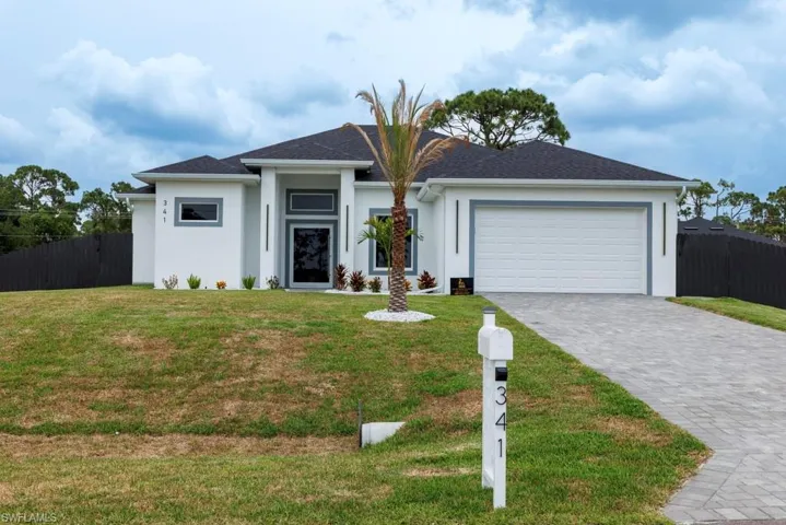 View of front of home featuring stucco siding, an attached garage, and decorative driveway