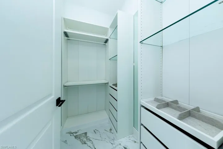Walk in closet with light marble finish floors