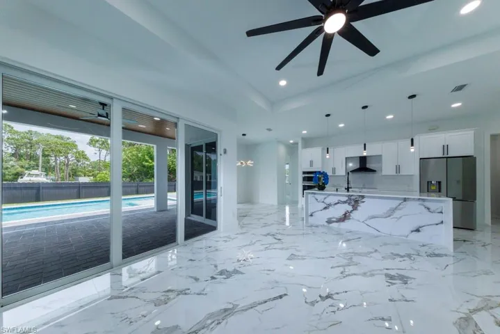 Unfurnished living room with ceiling fan, recessed lighting, and a sink