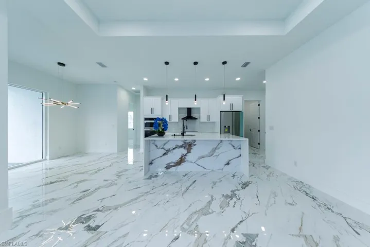 Living room with recessed lighting, a chandelier, and light marble finish floors
