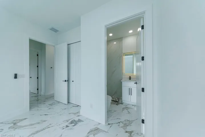 Hall with marble finish flooring, baseboards, and recessed lighting