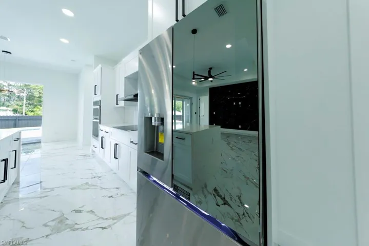 Kitchen with white cabinetry, appliances with stainless steel finishes, recessed lighting, light countertops, and a ceiling fan
