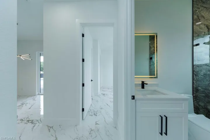 Corridor featuring light marble finish floors and a sink