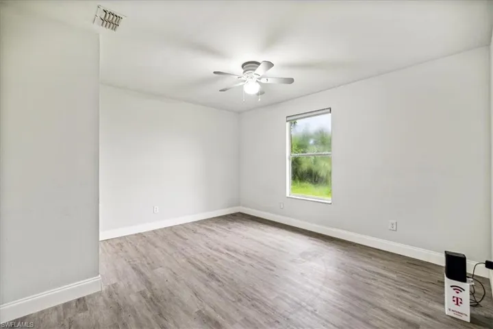 Unfurnished room featuring ceiling fan and hardwood / wood-style floors