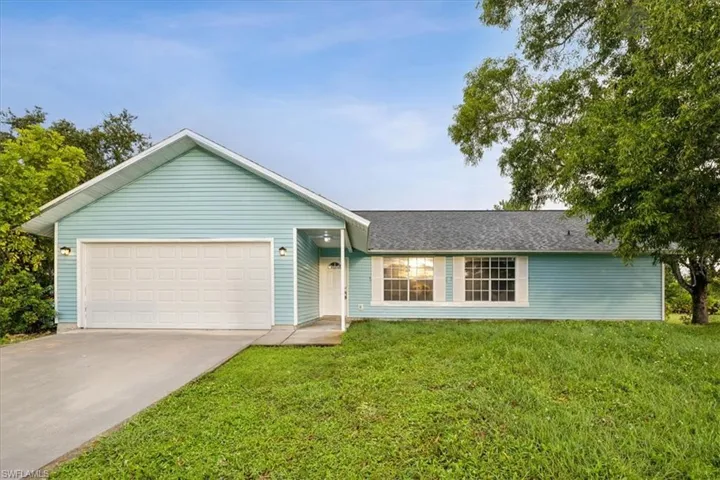 Single story home featuring a front lawn and a garage