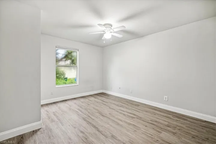 Empty room with light hardwood / wood-style floors and ceiling fan