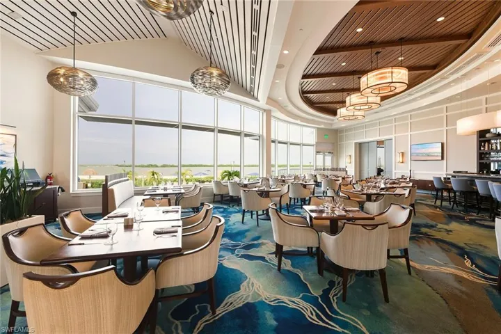 Carpeted dining room with a high ceiling, recessed lighting, and wooden ceiling