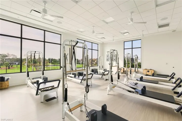 Exercise room featuring a ceiling fan and a paneled ceiling