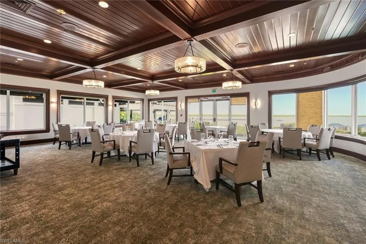 Dining area with a wood ceiling with exposed beams, dark colored carpet, healthy amount of natural light, and coffered ceiling