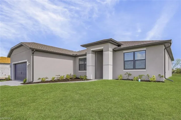 View of front of house featuring a garage and a front lawn