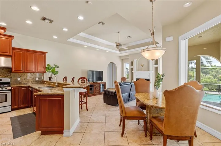 Kitchen with a peninsula, gas range, backsplash, ceiling fan, and arched walkways