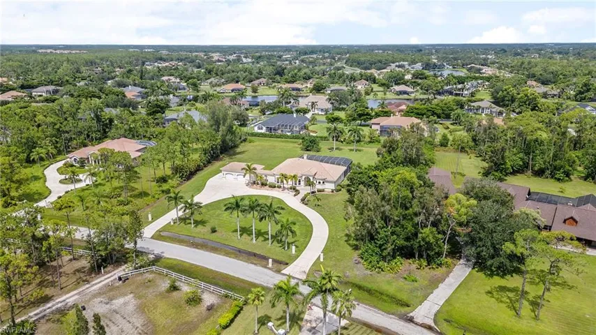 Aerial view of property and surrounding area with nearby suburban area