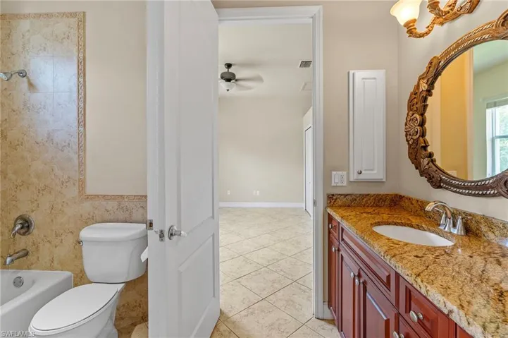 Bathroom with vanity, tile patterned floors, a ceiling fan, and bathtub / shower combination