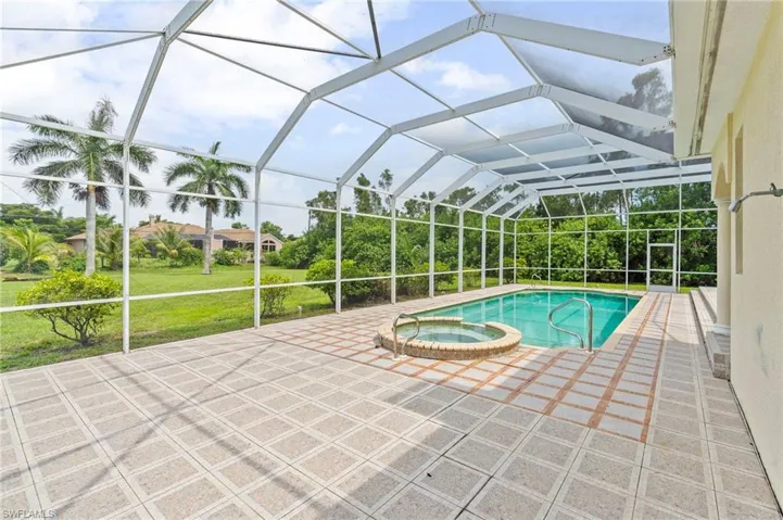 View of pool featuring a pool with connected hot tub, a patio, and a lanai