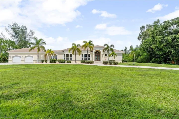 Mediterranean / spanish home with a front yard, concrete driveway, an attached garage, and stucco siding