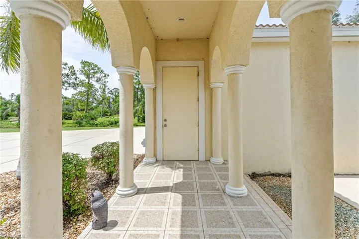 Property entrance featuring stucco siding and a tile roof