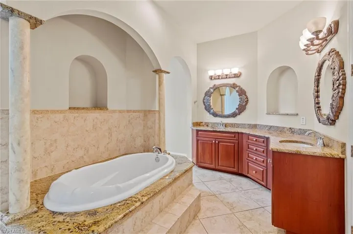 Bathroom with double vanity, a garden tub, and tile patterned floors
