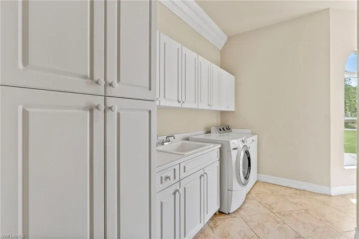 Washroom with cabinet space and washing machine and dryer