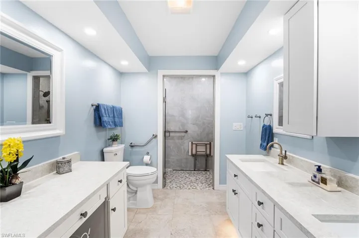 Bathroom featuring toilet, recessed lighting, a tile shower, and vanity