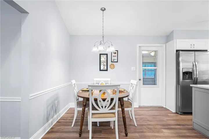 Dining space with wood finished floors and an inviting chandelier