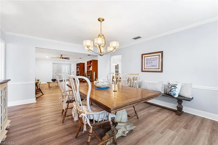 Dining room with ornamental molding, light wood-type flooring, and baseboards