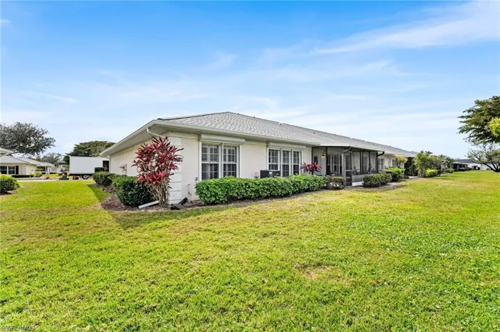 Rear view of property featuring stucco siding and a yard