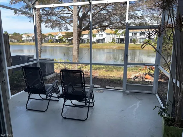 Sunroom featuring a water view and a residential view