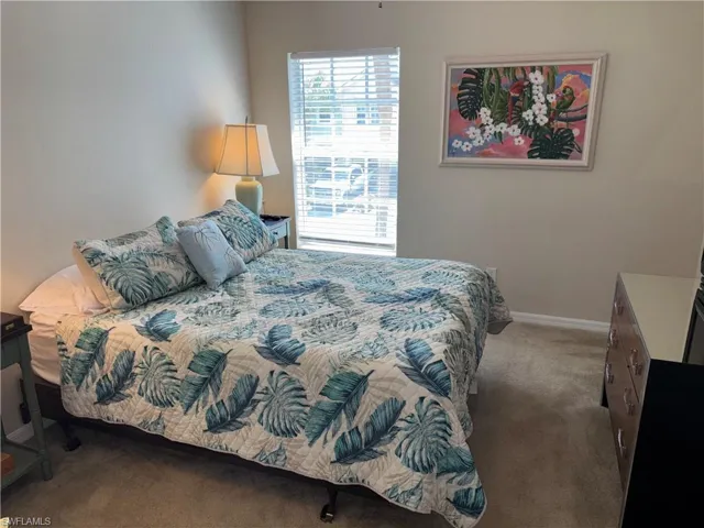Bedroom featuring dark carpet and baseboards