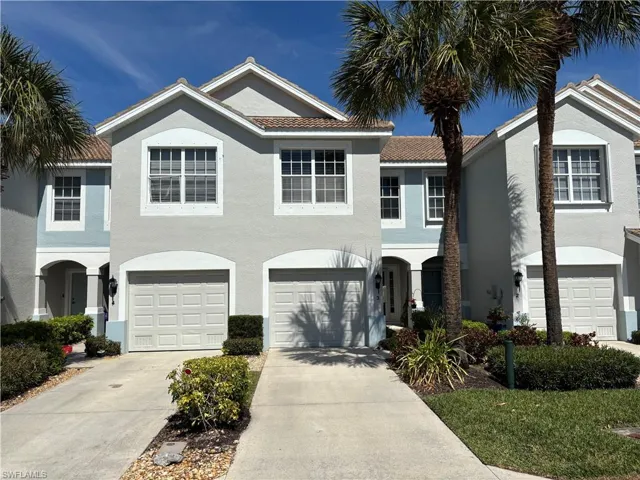 View of front of house with driveway, stucco siding, an attached garage, and a tile roof