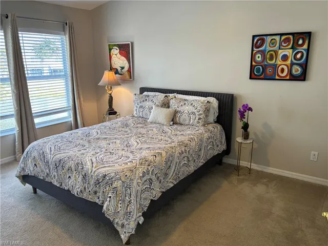 Bedroom with light carpet and baseboards