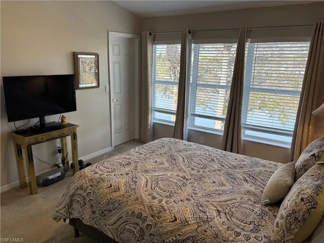 Bedroom featuring baseboards and light carpet