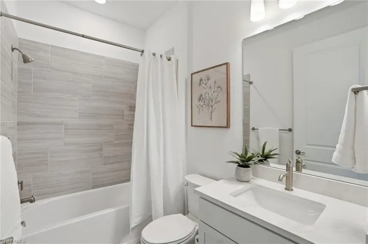 Full bath featuring shower / bathtub combination with curtain and vanity