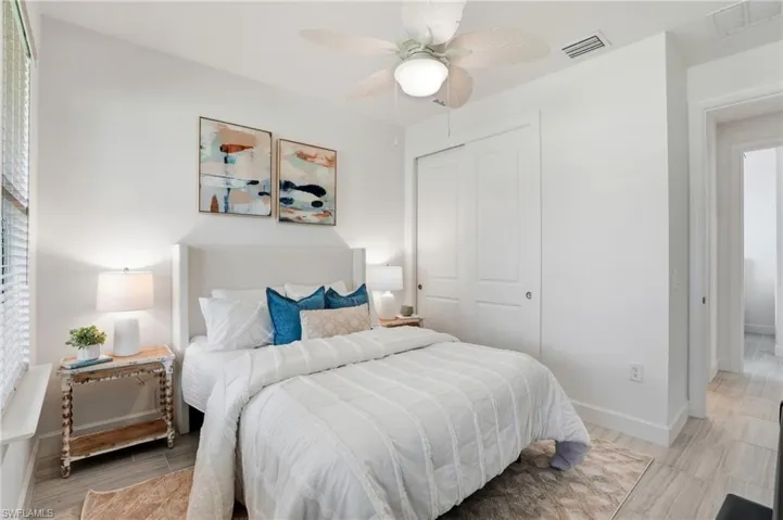Bedroom with wood tiled floors, a closet, and a ceiling fan