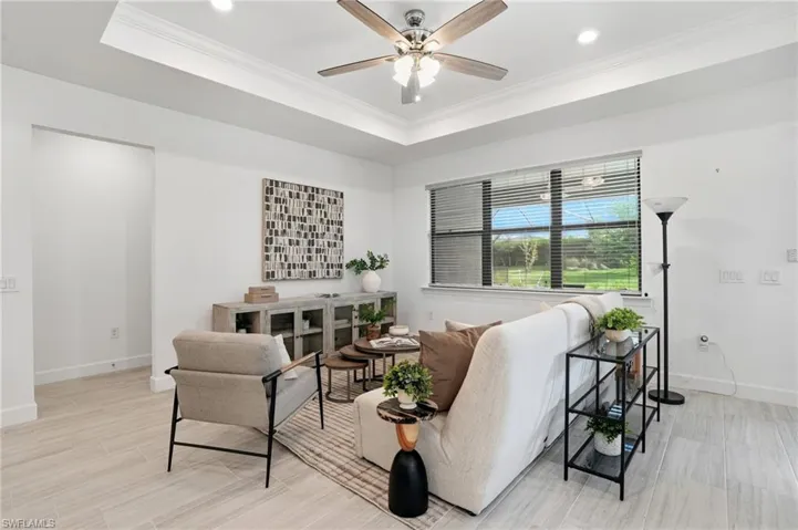Living room featuring crown molding, a raised ceiling, wood tiled floors, a ceiling fan, and recessed lighting