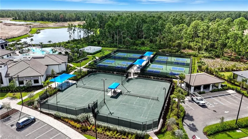 Drone / aerial view of a nearby body of water and a heavily wooded area