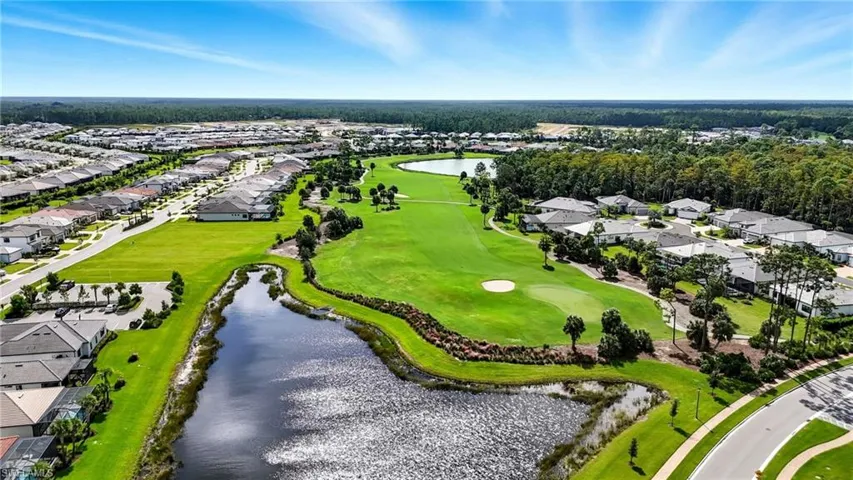 Aerial view of residential area featuring a large body of water and a golf club