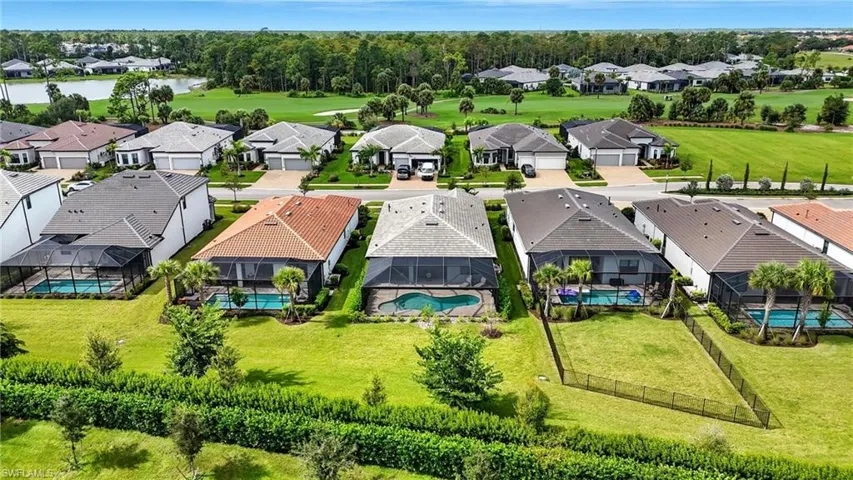 Aerial perspective of suburban area with a pool area and a large body of water