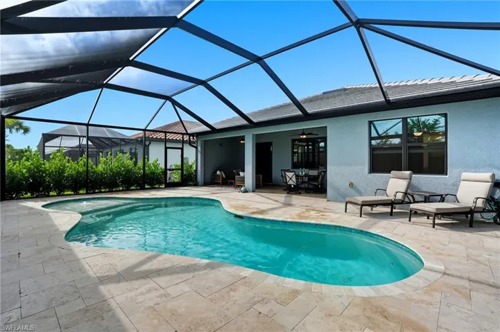 Outdoor pool with glass enclosure, a sunroom, ceiling fan, and a patio area