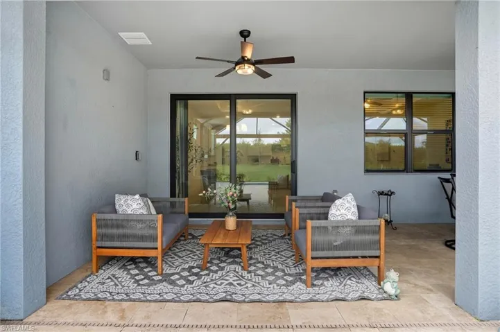 Living area featuring a textured wall and a ceiling fan
