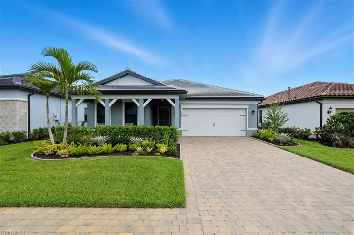 Ranch-style house featuring a front lawn, stucco siding, decorative driveway, and an attached garage
