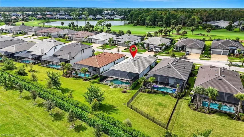 Aerial view of residential area featuring a large body of water and a pool area