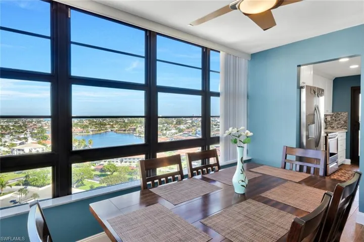 Dining area with ceiling fan and a water view