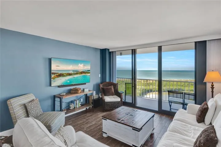 Living area featuring floor to ceiling windows and wood tiled floors