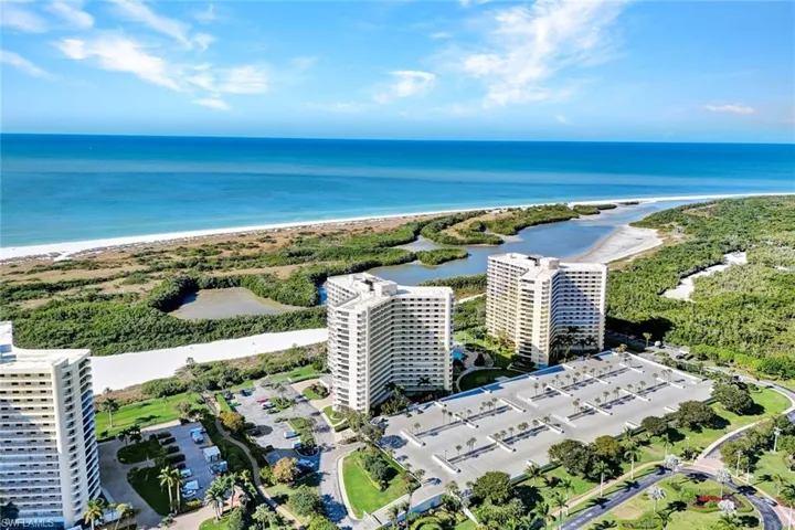 Drone / aerial view of unending shoreline and apartment complex / building
