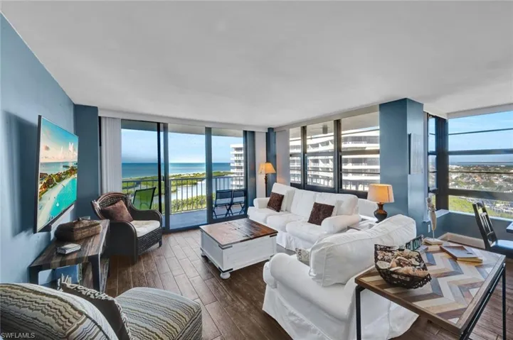 Living area with wood finished floors, plenty of natural light, and expansive windows