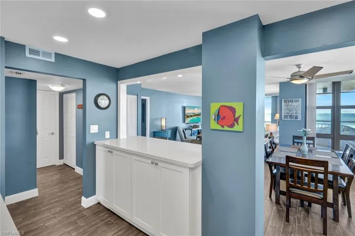 Kitchen featuring wood tiled floors, white cabinetry, recessed lighting, light countertops, and ceiling fan
