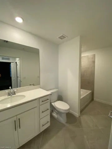 Full bathroom with vanity, light tile patterned flooring, and shower / tub combination