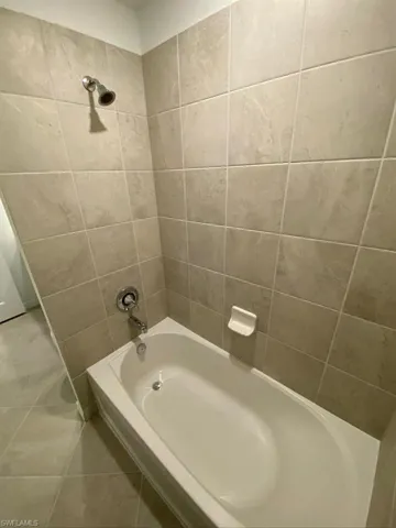 Bathroom with tub / shower combination and tile patterned floors